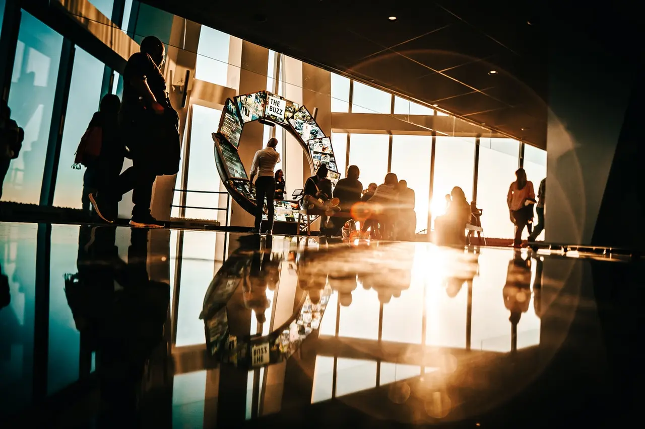 grupo de pessoas reunidas com o sol no fundo a brilhar