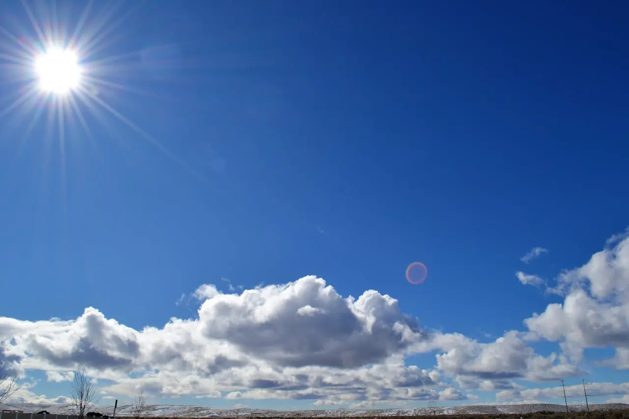 blue sky with shiny sun and white clouds